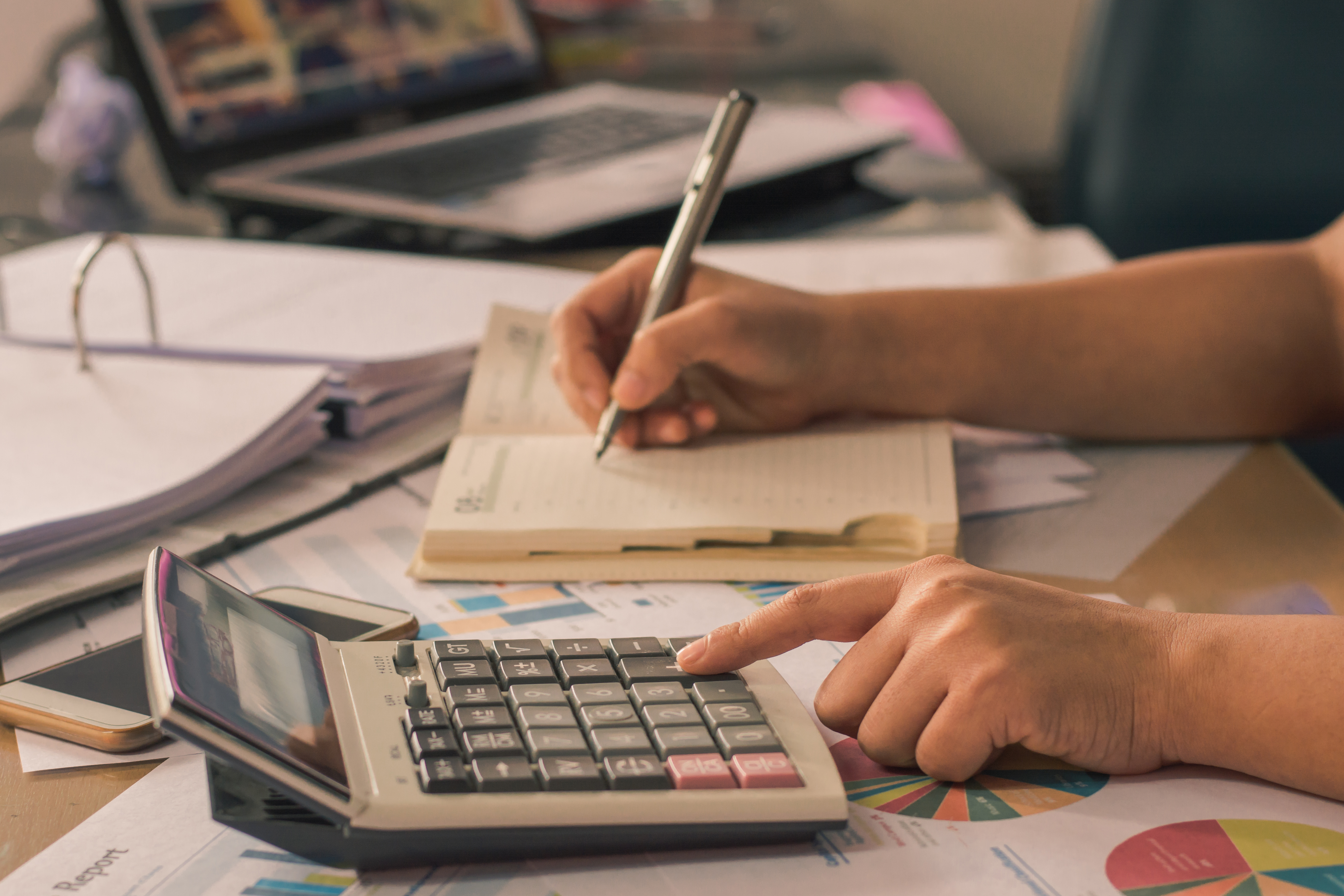 Man hand using a financial calculator with writing make note and
